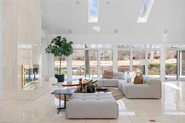 tiled living room featuring a towering ceiling and a skylight