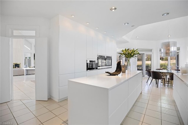 kitchen featuring modern cabinets, stainless steel oven, white cabinets, and a center island