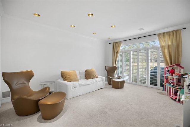 sitting room featuring ornamental molding, carpet, and visible vents