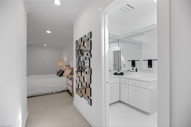 interior space featuring crown molding, recessed lighting, visible vents, ensuite bathroom, and light carpet