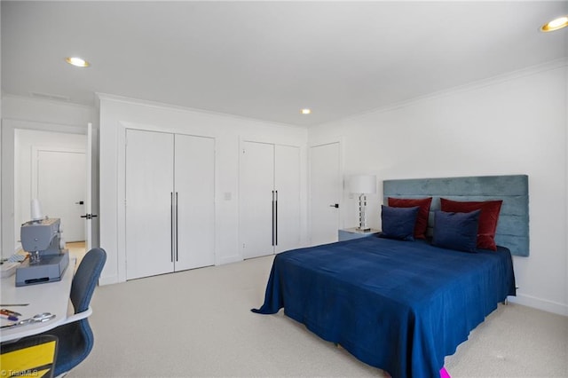 carpeted bedroom featuring crown molding, visible vents, multiple closets, and recessed lighting