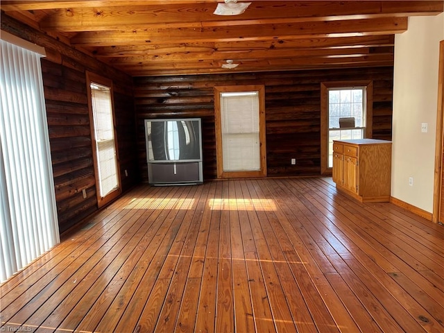 unfurnished living room featuring beamed ceiling and hardwood / wood-style floors