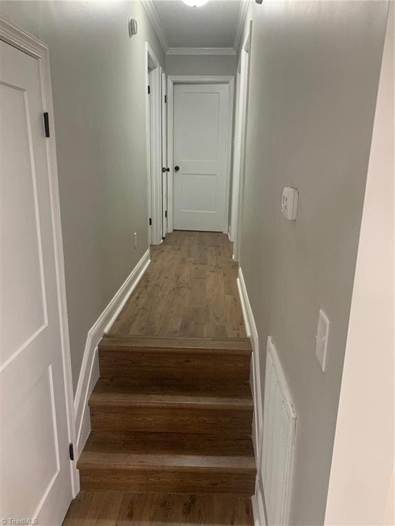 stairs featuring hardwood / wood-style flooring and ornamental molding