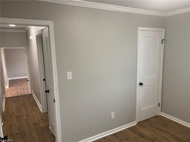 corridor with dark hardwood / wood-style floors and ornamental molding