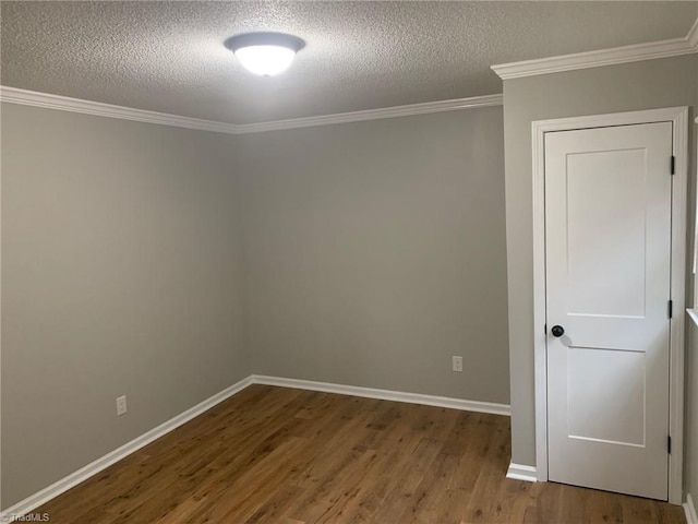 spare room featuring a textured ceiling, crown molding, and hardwood / wood-style floors