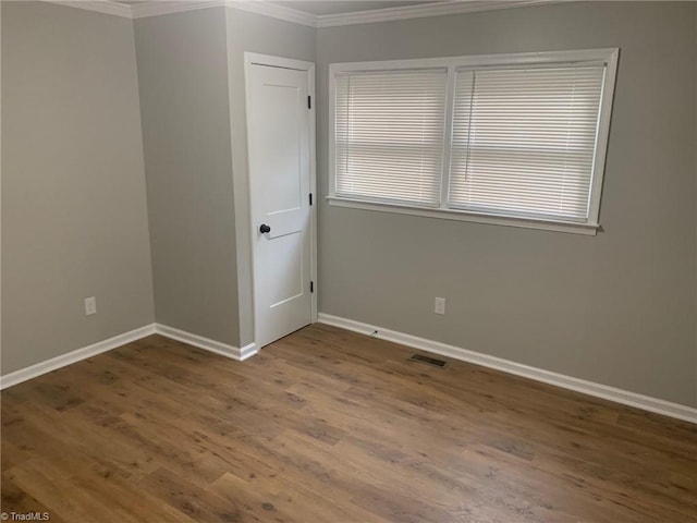 spare room with ornamental molding and wood-type flooring