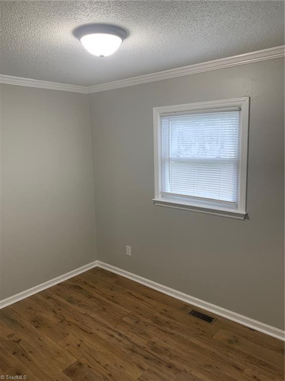 spare room with a textured ceiling, dark hardwood / wood-style flooring, and ornamental molding