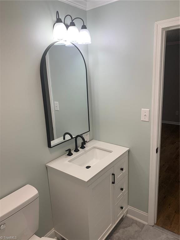 bathroom with tile patterned floors, vanity, crown molding, and toilet