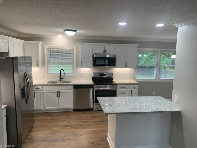 kitchen featuring appliances with stainless steel finishes, light wood-type flooring, sink, and a healthy amount of sunlight