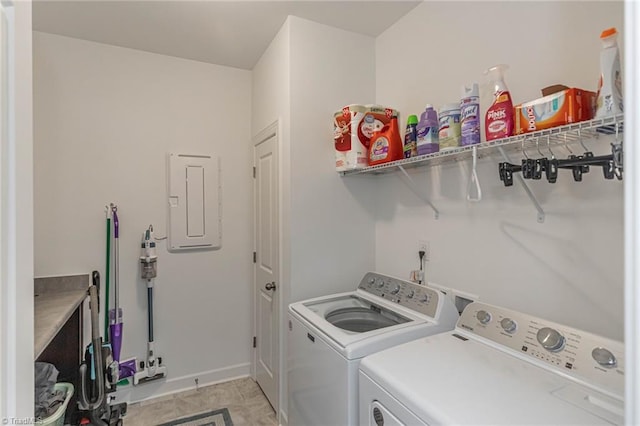 clothes washing area with laundry area, washing machine and clothes dryer, electric panel, and baseboards