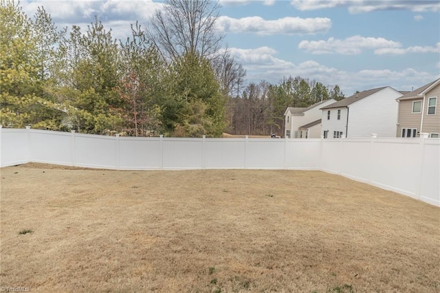 view of yard with a fenced backyard and a residential view