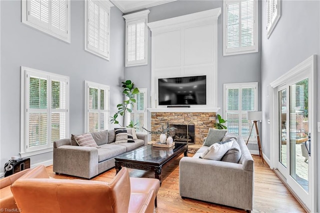 3940 Beechridge Rd, Winston-Salem, NC 27106 - living room featuring a towering ceiling, light wood finished floors, a stone fireplace, crown molding, and baseboards