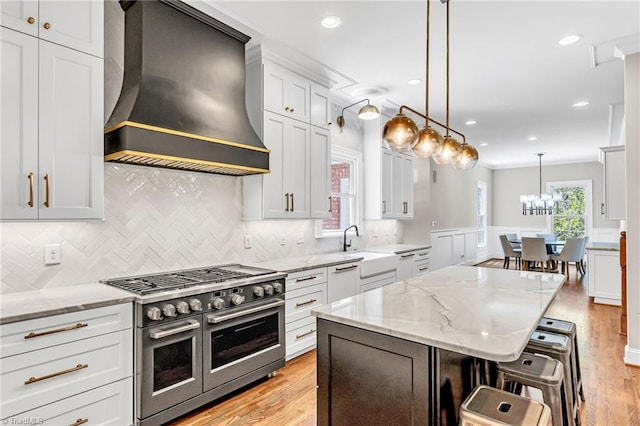 3940 Beechridge Rd, Winston-Salem, NC 27106 - kitchen with range with two ovens, custom exhaust hood, a kitchen breakfast bar, tasteful backsplash, and light wood-type flooring