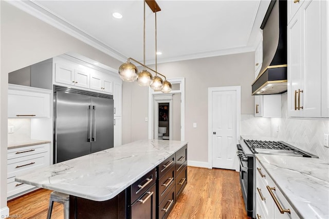 3940 Beechridge Rd, Winston-Salem, NC 27106 - kitchen featuring high quality appliances, wall chimney exhaust hood, white cabinetry, backsplash, and light wood-type flooring