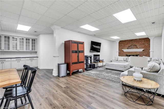 3940 Beechridge Rd, Winston-Salem, NC 27106 - living room featuring wood finished floors, a paneled ceiling, a brick fireplace, and baseboards