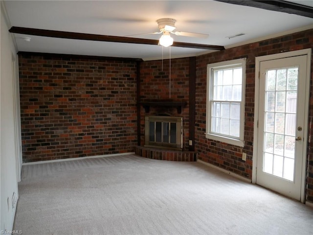 unfurnished living room featuring beamed ceiling, brick wall, a brick fireplace, and light carpet