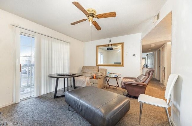 living area featuring carpet floors and ceiling fan