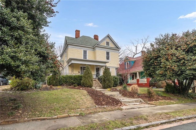 view of front of home with a front yard and covered porch