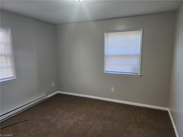 empty room featuring a baseboard radiator and dark colored carpet