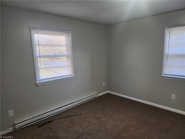 empty room with baseboard heating and dark colored carpet