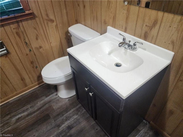 bathroom featuring wooden walls, toilet, vanity, and hardwood / wood-style flooring