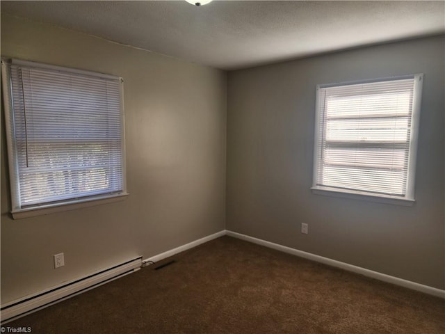 carpeted empty room with a baseboard radiator