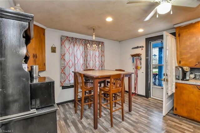 dining area with crown molding, ceiling fan, and wood-type flooring