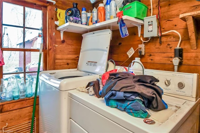 laundry room featuring separate washer and dryer and wood walls