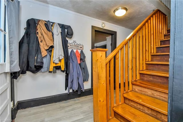 stairway featuring crown molding and hardwood / wood-style floors