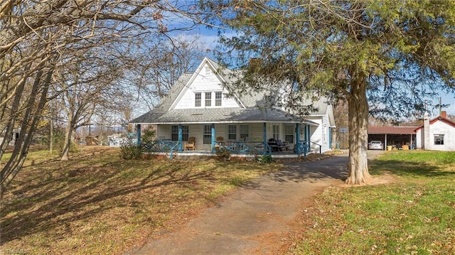 country-style home with a porch and a front lawn