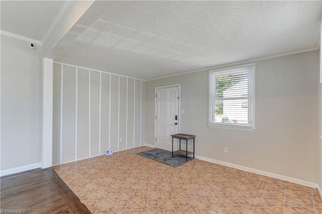 spare room featuring crown molding and a textured ceiling