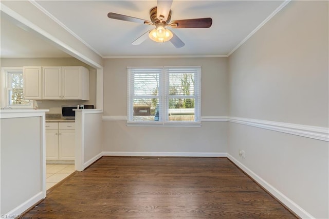 unfurnished dining area featuring dark wood-type flooring, ceiling fan, and ornamental molding