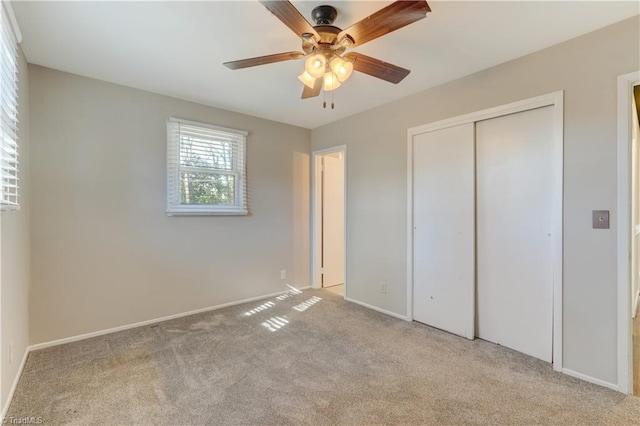 unfurnished bedroom featuring ceiling fan, a closet, and light carpet