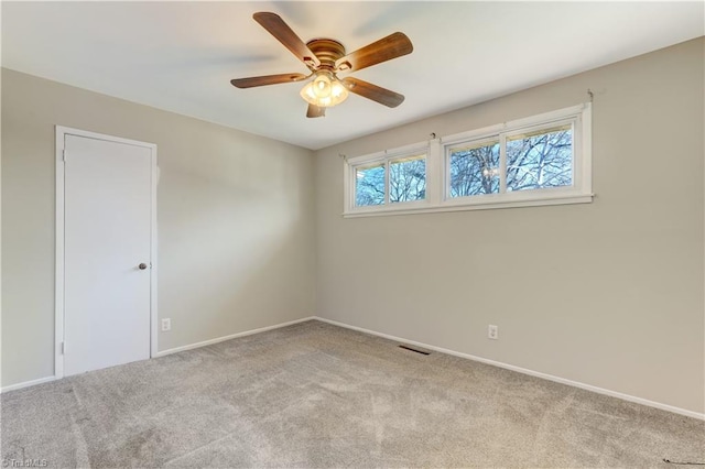 spare room featuring ceiling fan and light colored carpet