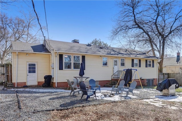 rear view of property with cooling unit and a fire pit