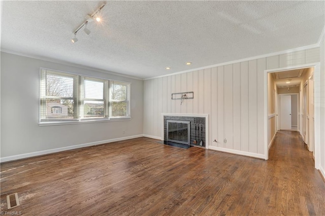 unfurnished living room featuring a textured ceiling, dark hardwood / wood-style flooring, and crown molding