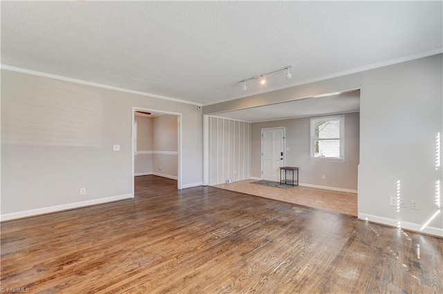 unfurnished living room featuring a textured ceiling, track lighting, ornamental molding, and hardwood / wood-style floors