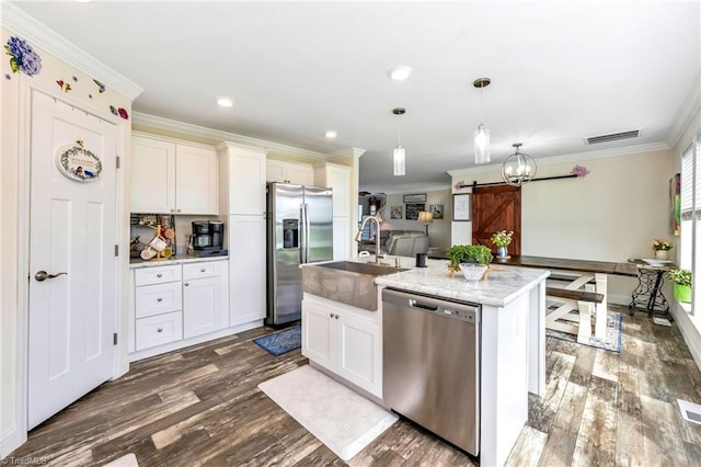 214 Mining Ridge Church Rd, Elkin, NC 28621 - kitchen with stainless steel appliances, a barn door, dark wood-type flooring, an island with sink, and crown molding