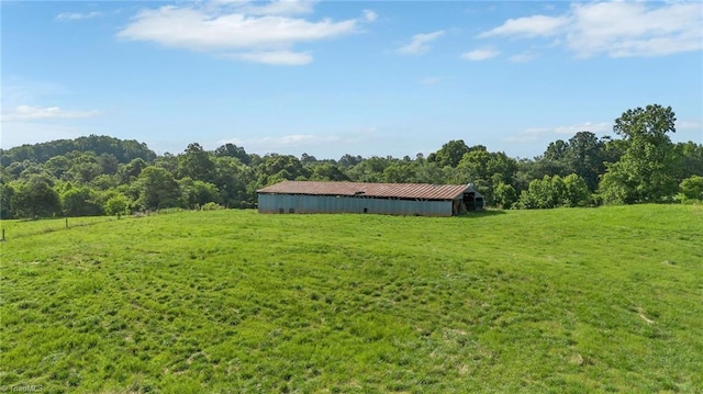 214 Mining Ridge Church Rd, Elkin, NC 28621 - view of green lawn with a pole building, a view of rural / pastoral area, an outdoor structure, and a forest view