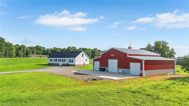 214 Mining Ridge Church Rd, Elkin, NC 28621 - rear view of house featuring a detached garage, a lawn, an outbuilding, and a pole building
