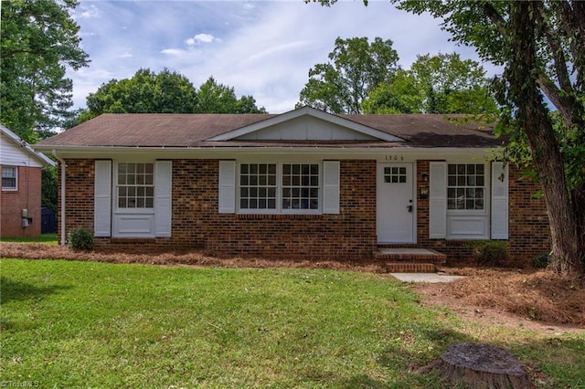 ranch-style home featuring brick siding, board and batten siding, and a front yard