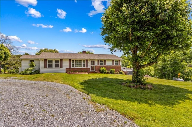 single story home with a chimney, a front lawn, and gravel driveway