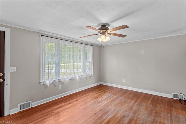 unfurnished room featuring ceiling fan, light wood-style floors, baseboards, a textured ceiling, and ornamental molding