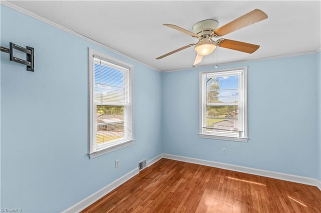 spare room featuring baseboards, healthy amount of natural light, ornamental molding, and ceiling fan