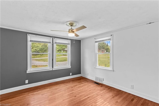 spare room with a ceiling fan, light wood-style flooring, baseboards, and ornamental molding
