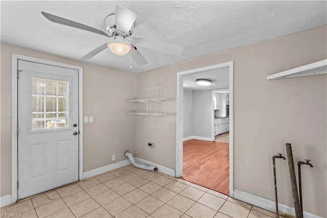 laundry area with hookup for an electric dryer, ceiling fan, baseboards, and light tile patterned floors