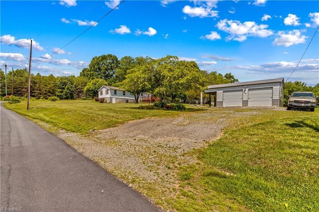 single story home with a garage, a front lawn, and an outdoor structure