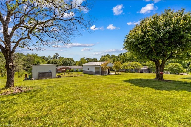 view of green lawn featuring an outbuilding