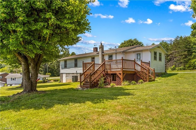 rear view of property with stairway, a wooden deck, a yard, and a chimney
