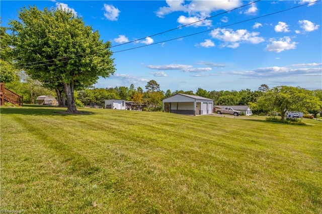 view of grassy yard with a garage and an outdoor structure